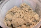 Tan, sandy dry sift collected in a plastic container on a pollen-box screen