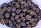 Black peppercorns on a spoon, a natural source of beta-caryophyllene